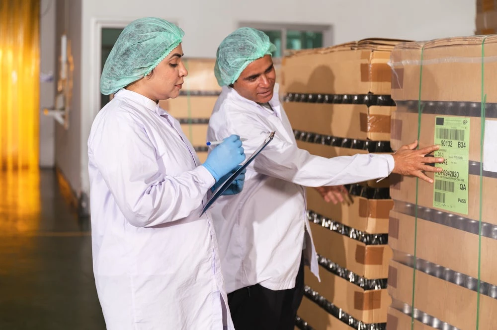 Two inspectors at a glass factory. (Shutterstock.com/Chachamp)