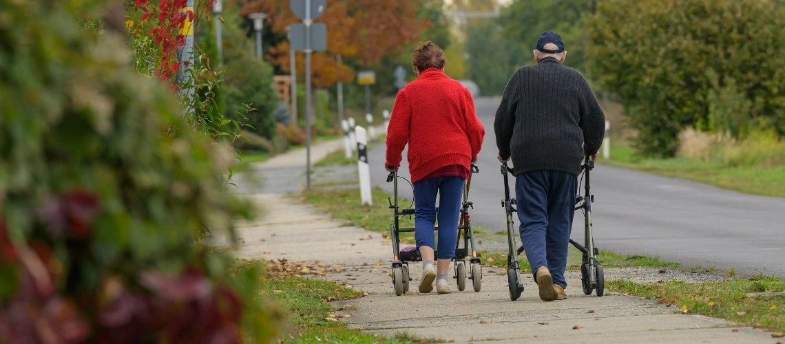 An elderly couple on the move with a rollator