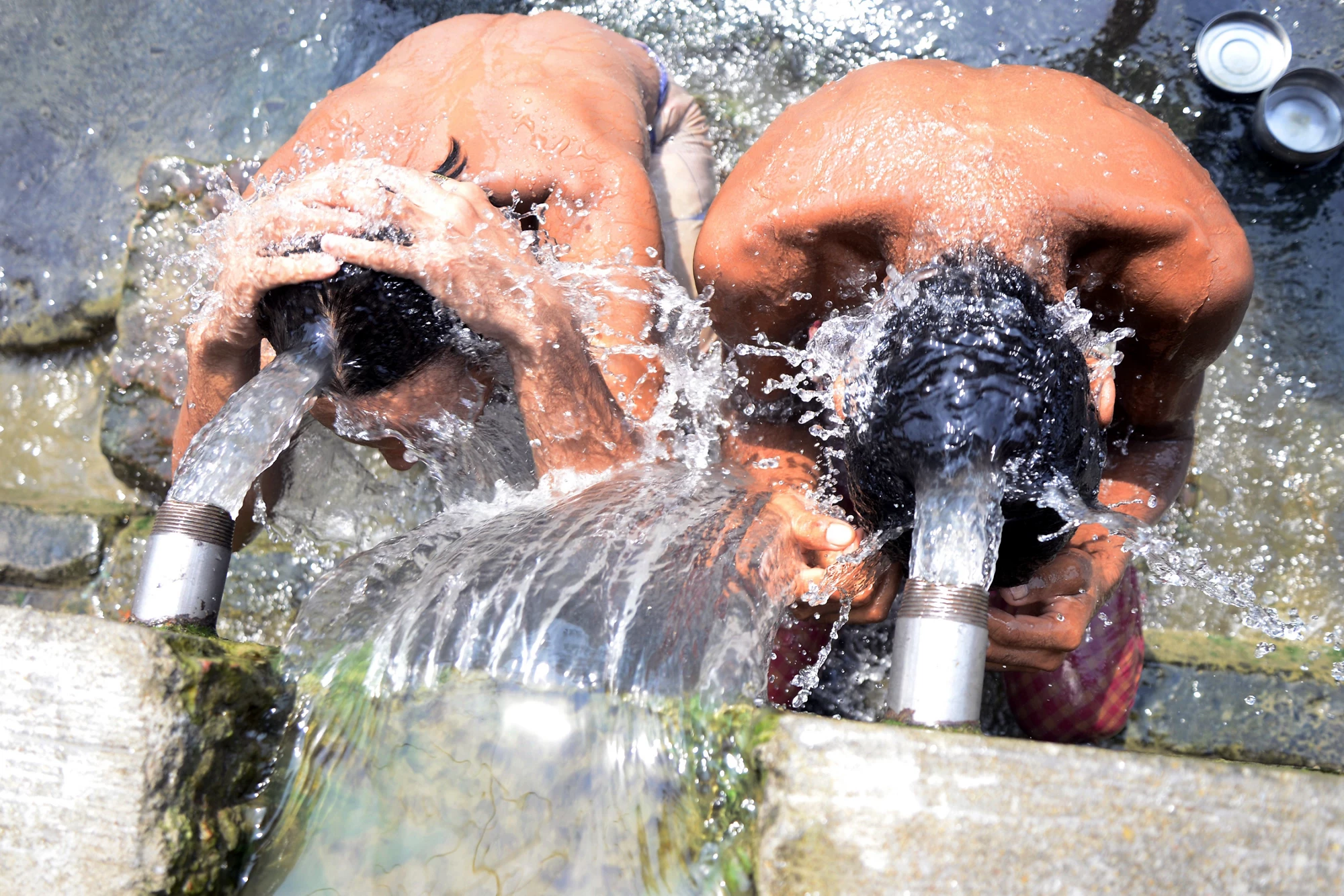 Local people bathe from municipal water source to keep themselves cool from heat wave on June 10, 2015 in Calcutta, India. Credit: Saikat Paul / Shutterstock.com