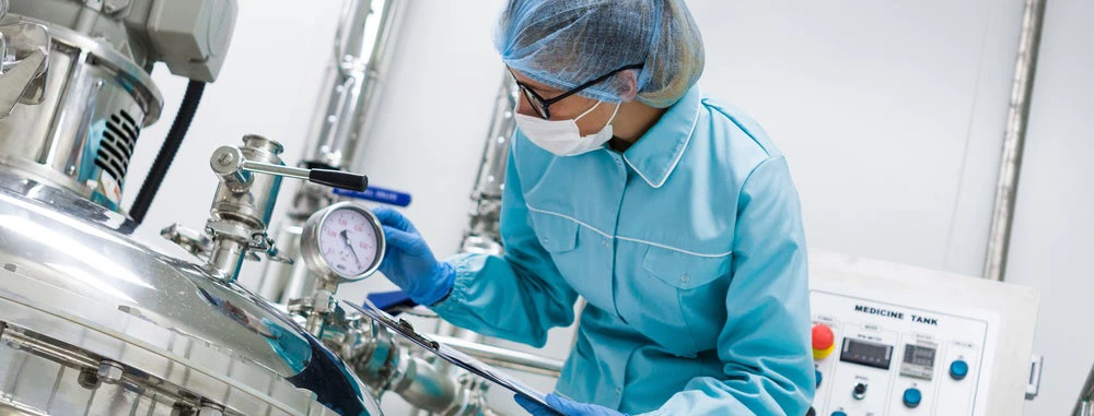 Woman working with large vat in lab.