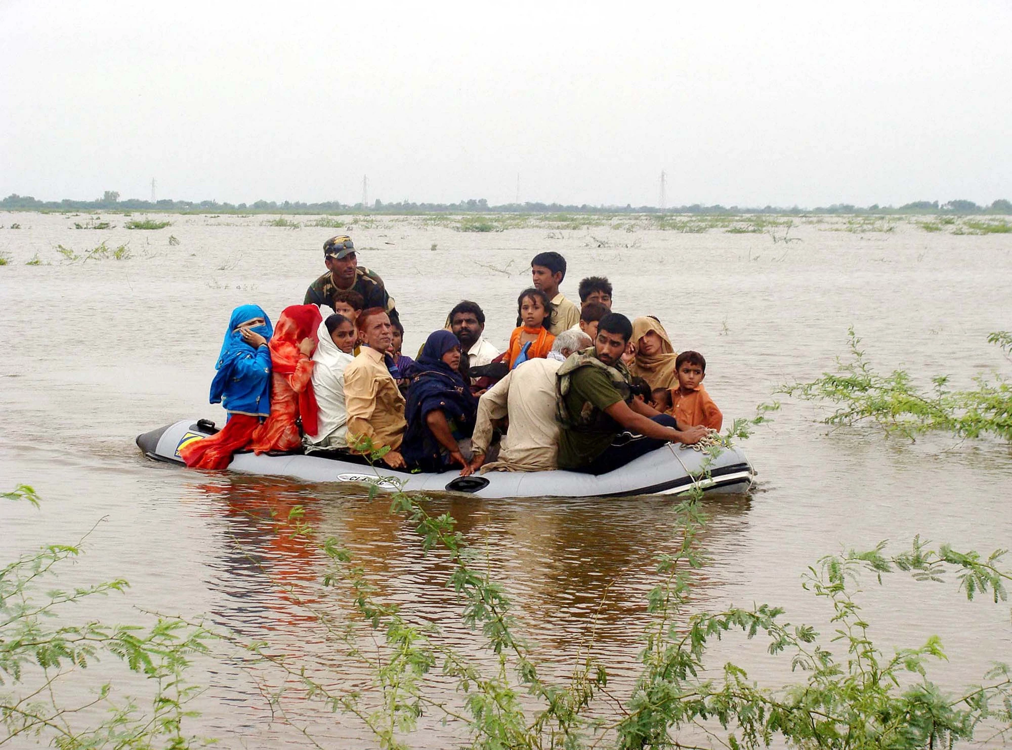 Navy soldiers shift flood-affected people towards safe place on boat at a flooded area due to heavy downpour of Monsoon season in Badin, Pakistan, 2011. Photo: Asianet-Pakistan/ Shutterstock