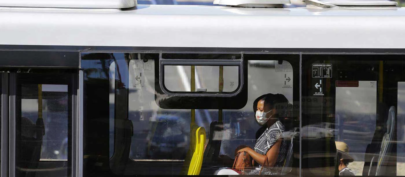 Una mujer es vista a través de la ventana de un autobús público con una máscara facial para protegerse de la COVID-19 en el centro de Sao Paulo, Brasil. Fotografía: © Nelson Antoine/Shutterstock