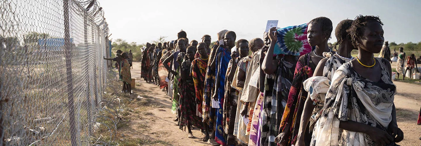 A line women waiting in a refugee camp