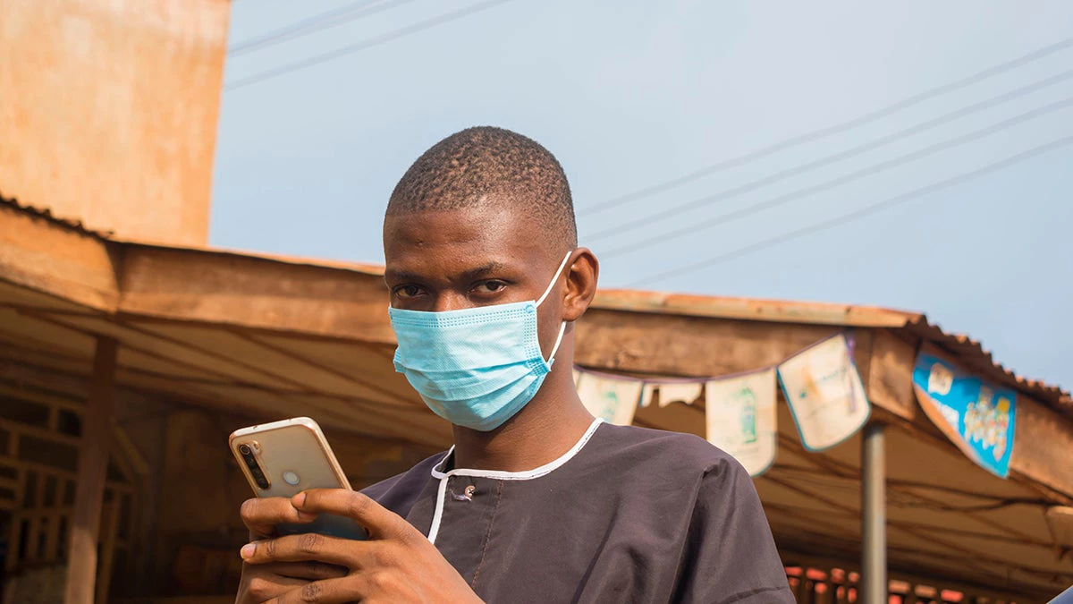 Smartphone user with a mask. Photo: Vic Josh/Shutterstock