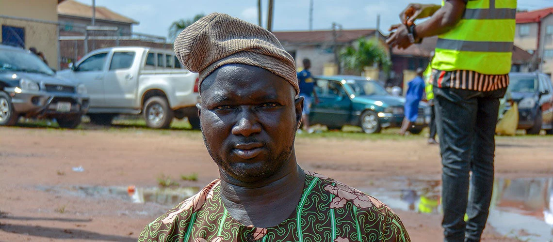 A physically challenged man holds up his voter's card during the Edo Governorship election, in Benin City, Nigeria, on September 19, 2020.