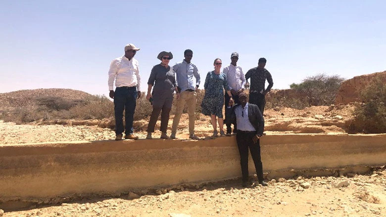 Some members of the Biyoole project standing on the wall of a dam (Credit: Biyoole Project)