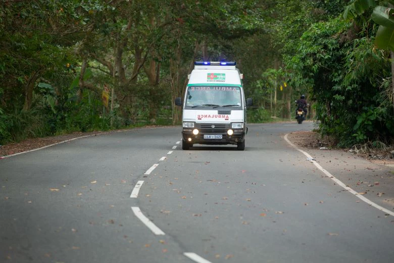 Ambulance driving down a quiet road in South Asia