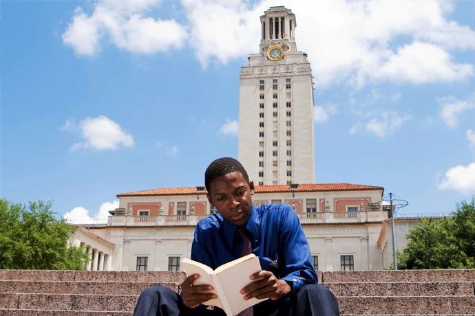 A student with University of Texas at Austin Tower in the background. © qingwa/iStock  