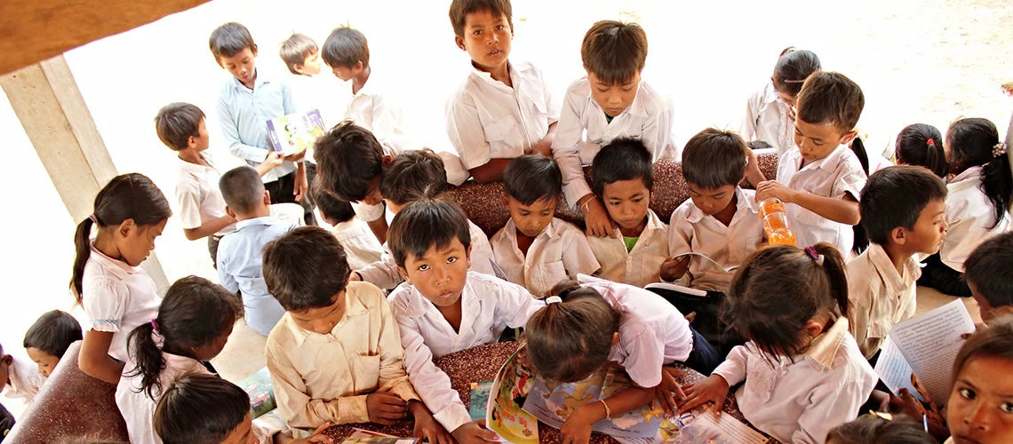 Students reading outside at the Angthlork Reang Sey School in Cambodia. | © Flickr.com | GPE/Livia Barton