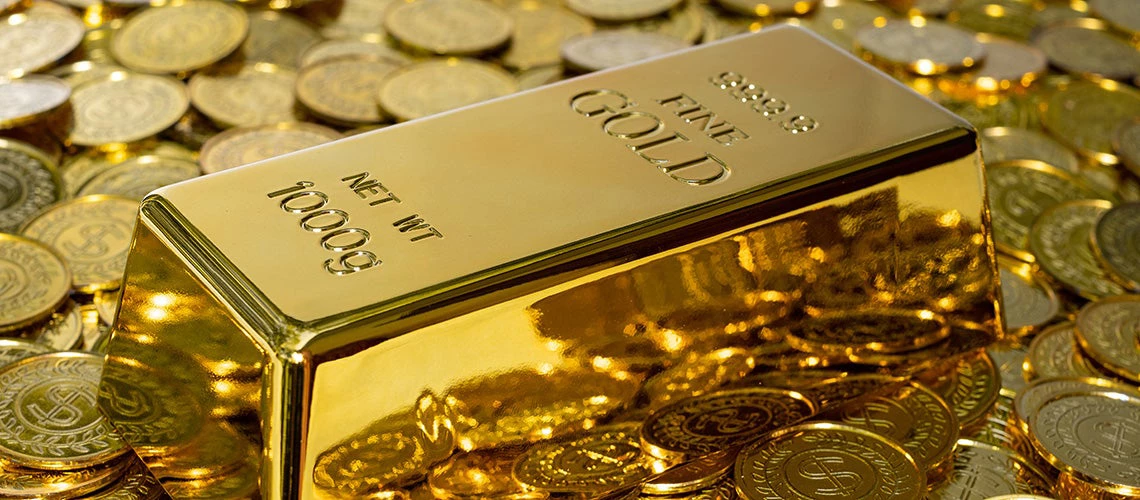 A gold bar on top of gold coins | © shutterstock.com