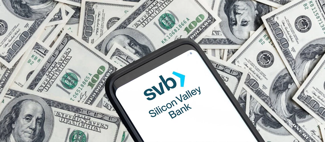 Cell phone with SVB over one hundred dollars bills. | © shutterstock.com and Adobe Stock