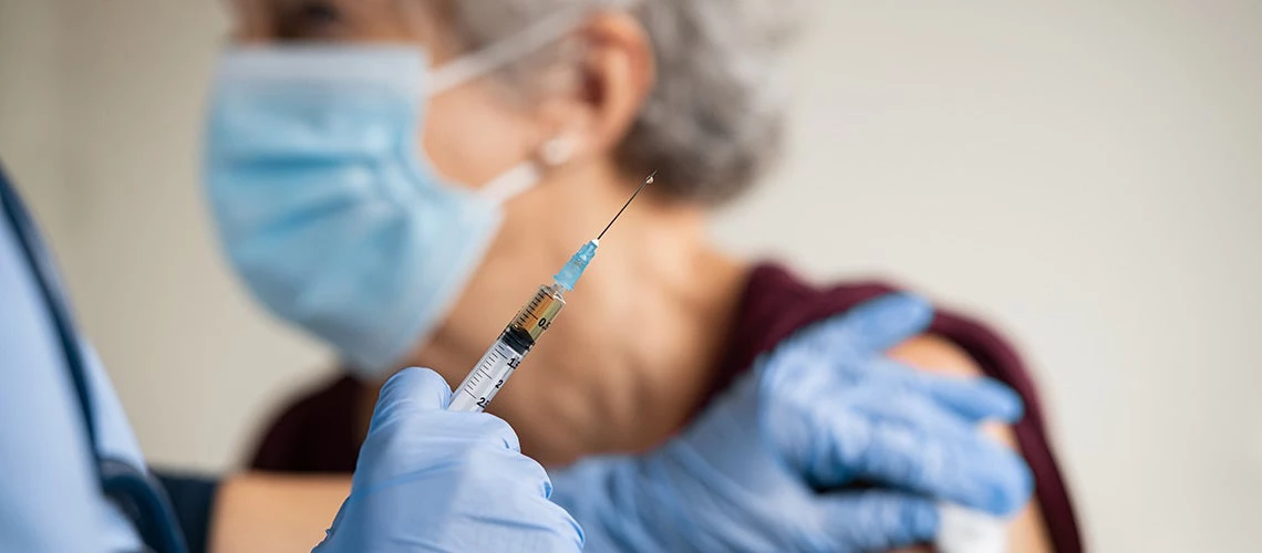 A nurse giving Covid-19 vaccine to an elderly woman. | © shutterstock.com