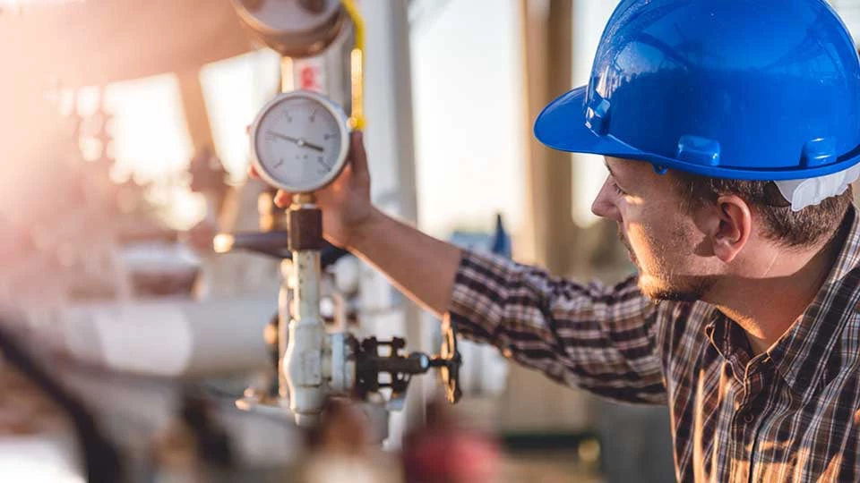 Man checking manometer in natural gas factory