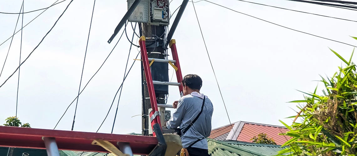 Technician troubleshoots internet fiber connection_Philippines Photo by MDV Edwards/Shutterstock.com