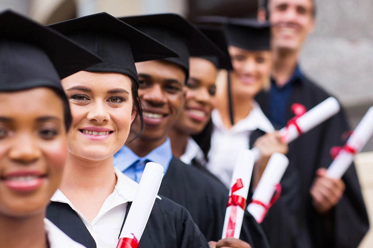Un groupe de diplômés universitaires  heureux se tenant en rang. Copyright (c) 2014 michaeljung/Shutterstock