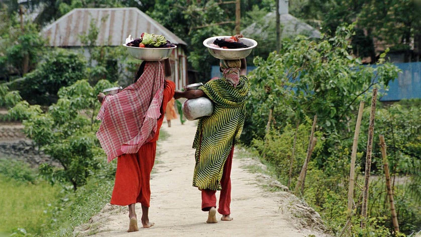 Two women carry clothing, produce, and water jugs. 
