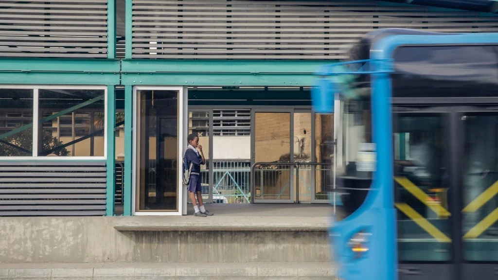 A young boy waits at a Bus Rapid Transit station in Dar es Salaam, Tanzania. Photo: Hendri Lombard/World Bank