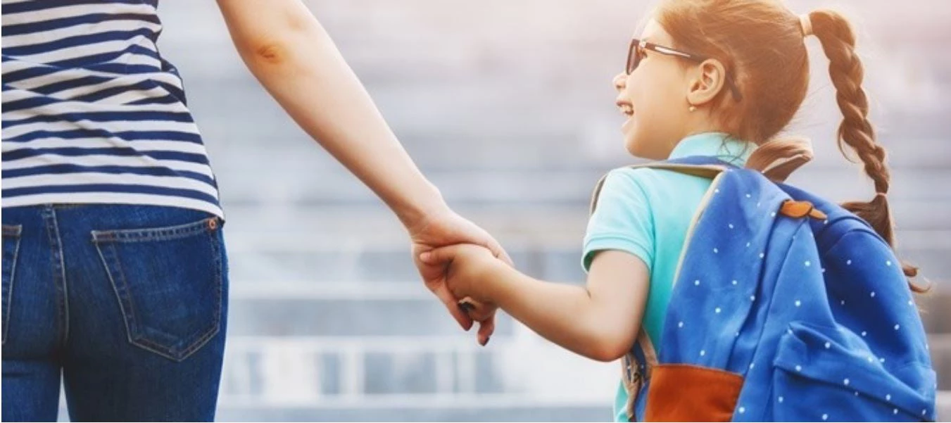 Niña caminando con su madre.