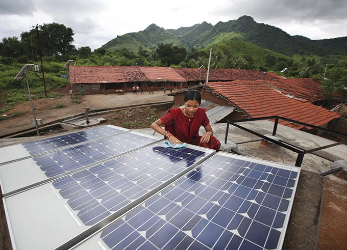Indian woman cleaning up solar panels in the province of Orissa, India