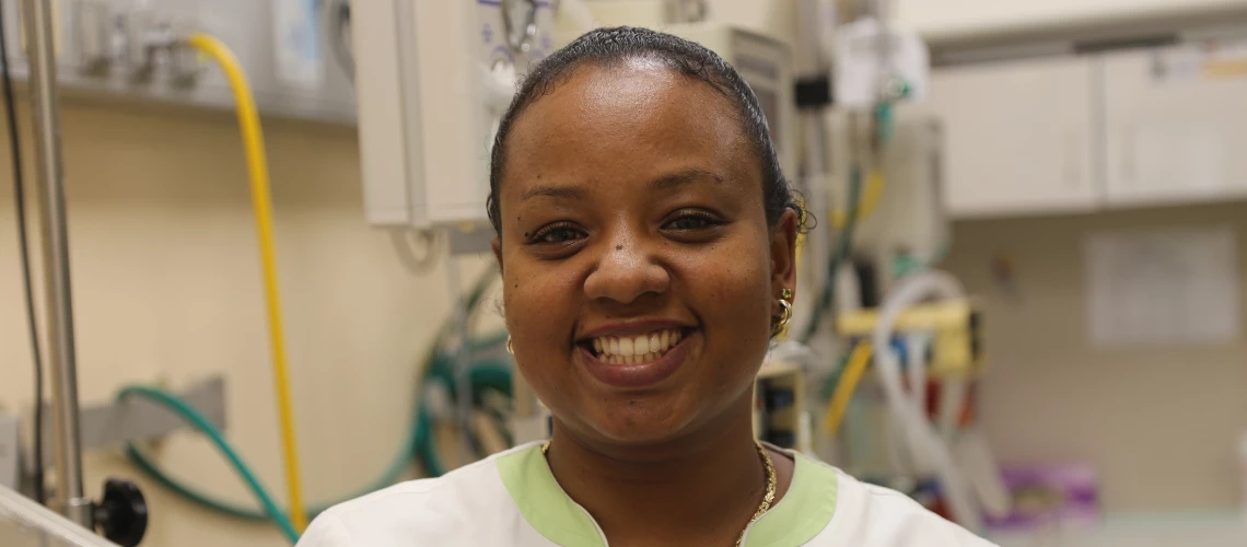 A nurse in Sint Marteen smiles on from a hospital room. 