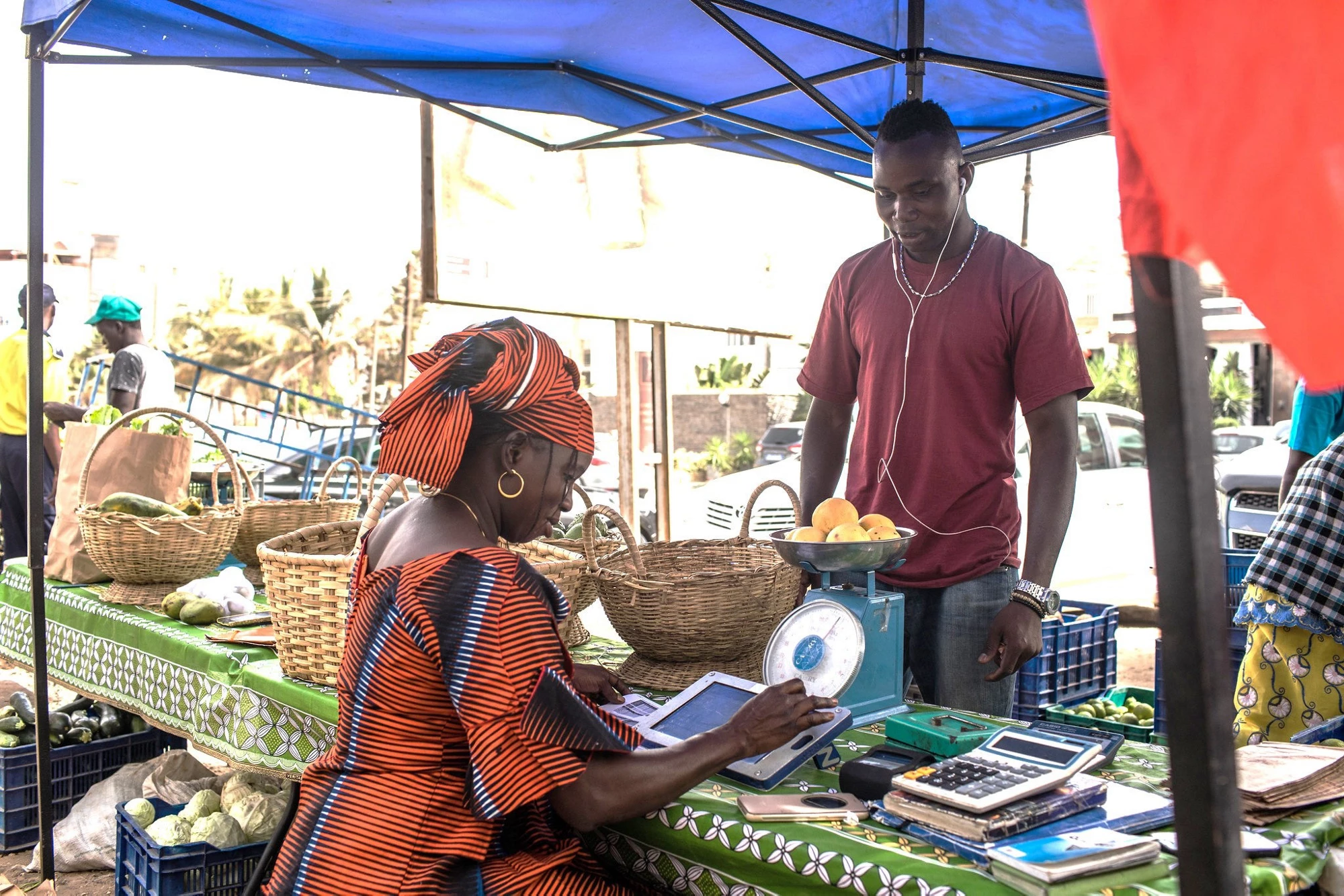 Binta is filling the vegetables she sells on her Weebi tablet. The application has helped her manage her stock and sales.