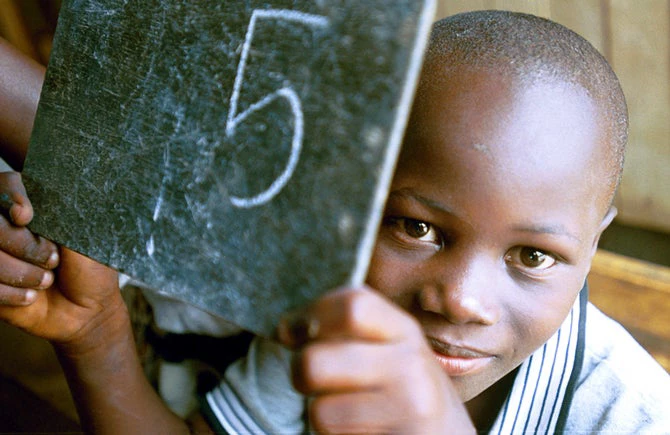 Un joven estudiante en Côte d'Ivoire muestra su trabajo escolar. © Ami Vitale / Banco Mundial