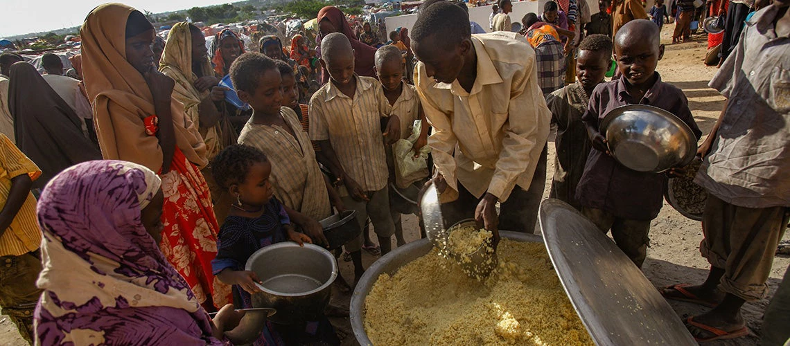 People are waiting in line for food delivery. Images from the Dadaab refugee camp in Somalia, where thousands of Somalis are waiting for help from hunger. | © shutterstock.com