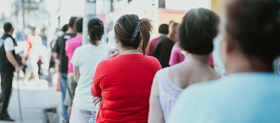 Large group of people waiting in line for Donation charity food. | © shutterstock.com