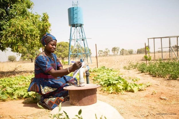 West-african Woman noting the water meter reading.