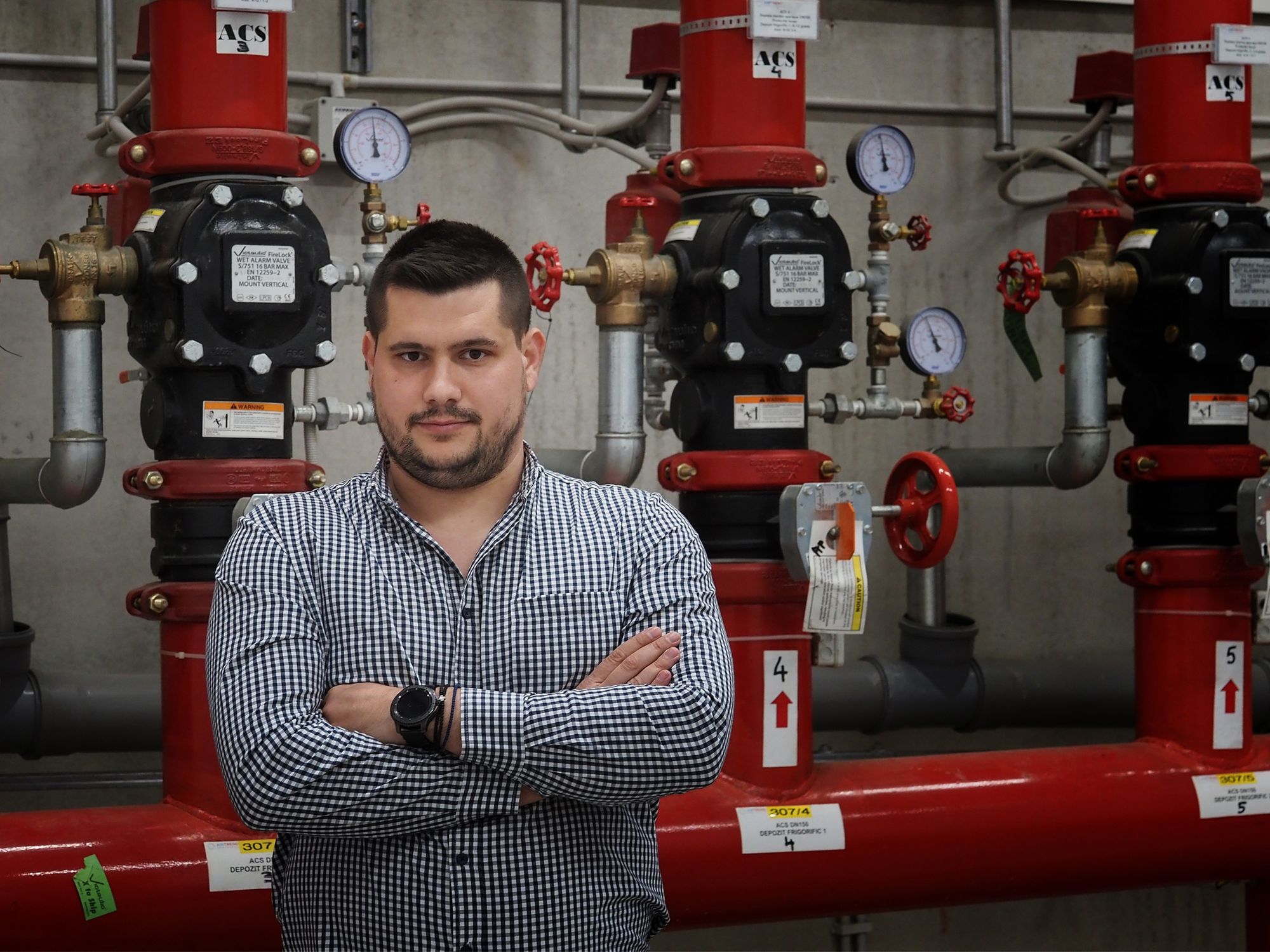 Facility Manager , Liviu Cepan, checks the water distribution assembly for sprinkler system at WDP Industrial Park in Romania. Photo: MirelaMomanu/IFC