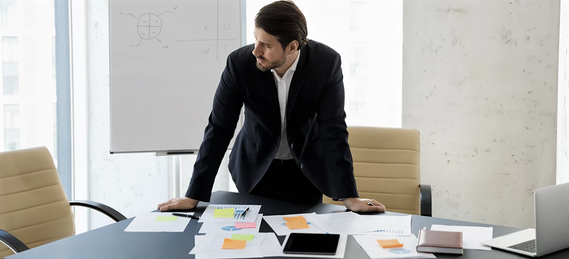 Business man standing at the table with sales reports.