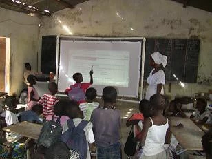 interacting with a whiteboard (in front of a blackboard) in Senegal