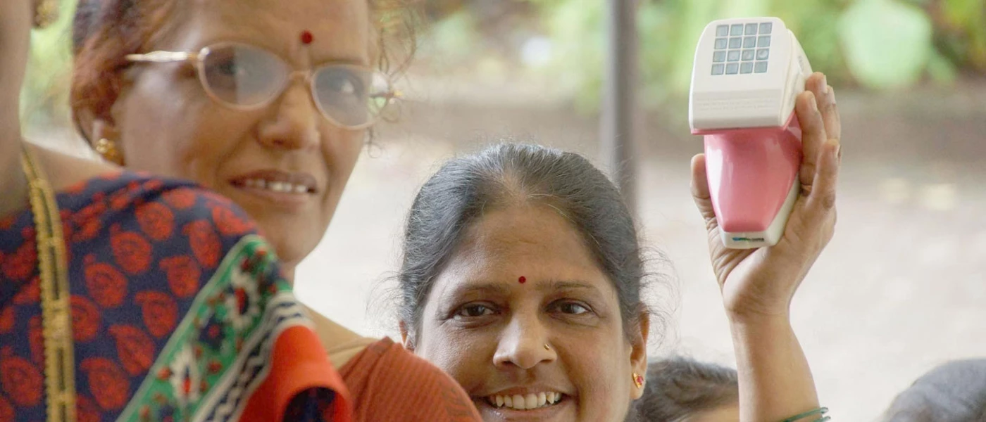 A woman holding up iBreastExam, a radiation-free device that is easy to use and requires minimal training for operators.