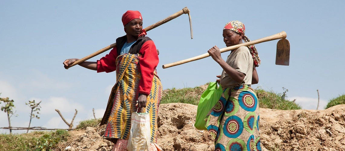 Women farmers from Rwanda in a field holding hoes