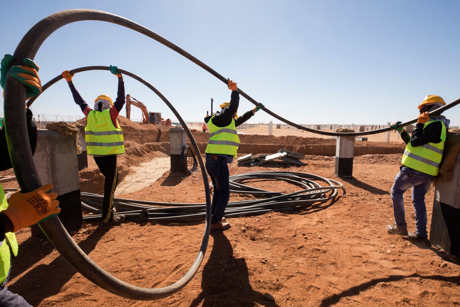 Mega Benban workers carry medium voltage cables in the Benban Solar Park in Benban, Egypt on December 11, 2018. Photo © Dominic Chavez/International Finance Corporation