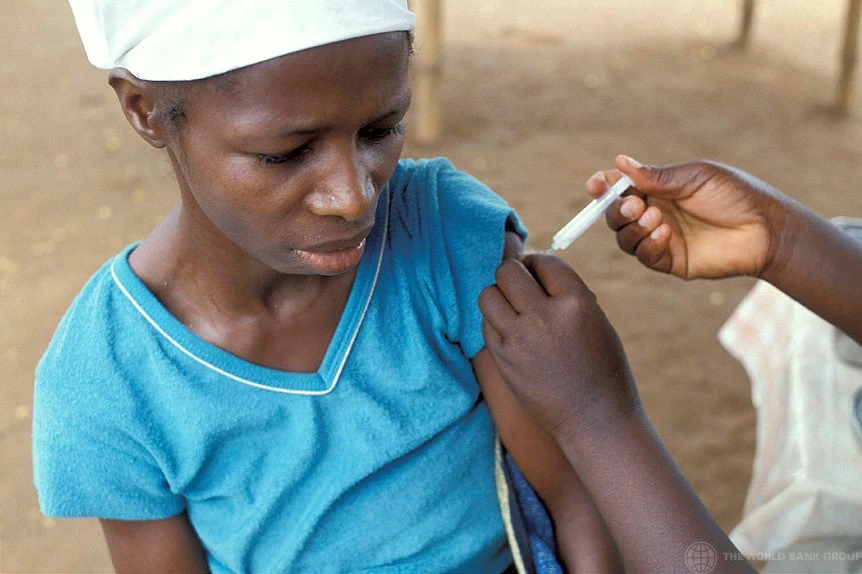 A healthcare worker is inoculating a woman with a COVID 19 vaccine